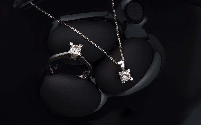 Diamond jewellery featured on black background.
