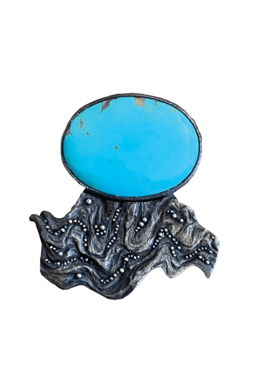 Kingman Turquoise cabochon (Arizona) accentuates a finely granulated casting of weather-worn burl wood in recycled silver by Jenn Dewey. (Photo: AMULET Arts)